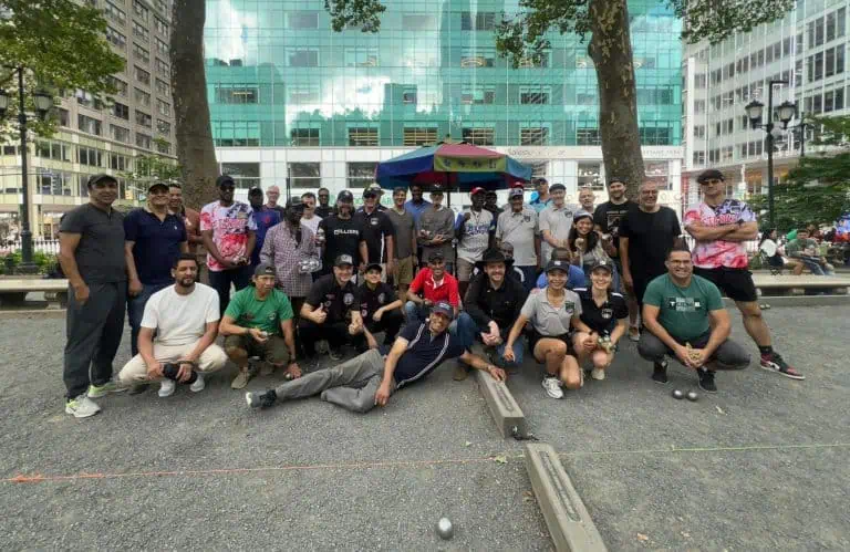 Grupo de personas jugando petanca en un parque urbano.