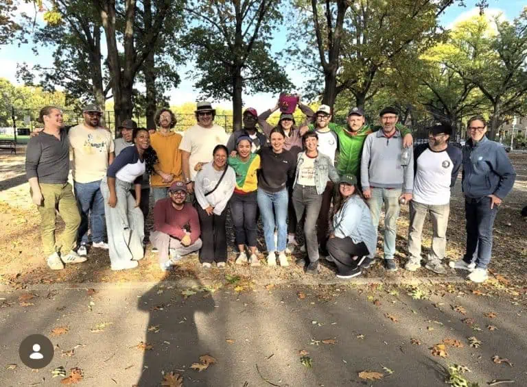 Disfrutando una partida amistosa de petanca en un parque pintoresco con jugadores diversos y árboles frondosos.