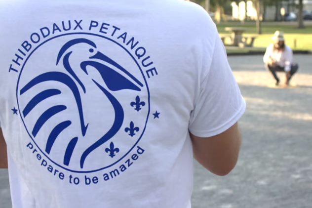 Thibodaux Pétanque Club T-shirt with logo and slogan in a park setting.