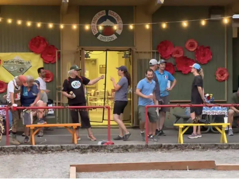 Groupe de personnes jouant à la pétanque au Portland Petanque Club avec des décorations festives.