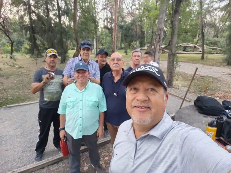 Groupe de personnes jouant à la pétanque à l’extérieur dans un boisé.